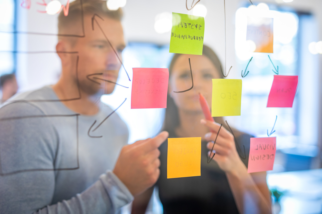 Two product managers review stickies in design sprint